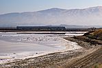 Morning Train Passing Alviso Marina Salt Ponds (35994875874) (cropped).jpg