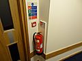 Fire extinguisher with ID sign, call point and fire action sign