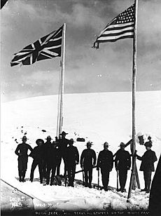 North-West Mounted Police standing next to American and British flags marking the boundary between Alaska and British Columbia (HEGG 446)