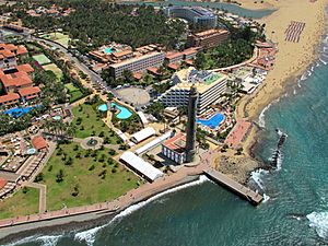 Aerial view of Faro de Maspalomas showing a cluster of hotel complexes, the lighthouse, beaches and sea