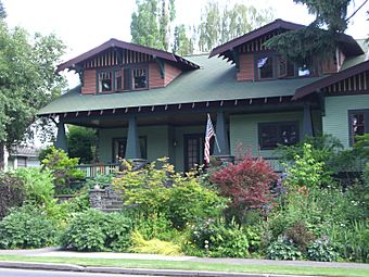 Photograph of a Craftsman bungalow with larger dormers, porch, and fieldstone steps.