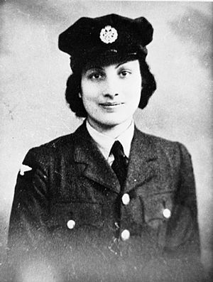 Young woman in uniform and cap smiles straight on to camera