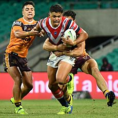 Latrell Mitchell tackled by the Brisbane Broncos