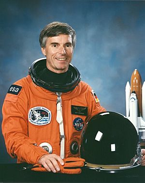 Ulf Merbold wearing an orange spacesuit
