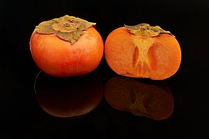 Fuyu persimmon fruits, one cut open