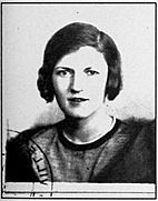 French identity card photo of Zelda Fitzgerald. She is facing the camera, and the picture has been stamped in the lower left corner. Zelda is wearing a mink coat and has uncharacteristically dark hair.