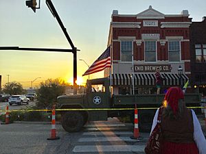 A woman walks across the street during sunset in downtown Enid, Oklahoma