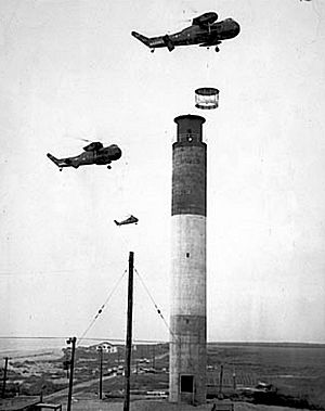 Marine Corps helicopters lifting light enclosure atop the Oak Island Lighthouse
