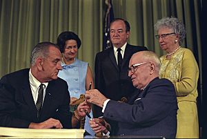 Photograph of President Lyndon Johnson Hands President Harry S. Truman a Pen at the Signing of the Medicare Bill at the Harry S. Truman Library, Independence, Missouri