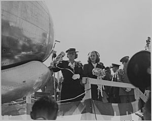 Bess Truman, accompanied by Margaret Truman, christens an airplane. Mrs. Truman is swinging a champagne bottle. - NARA - 199100