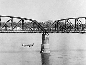 A Hawker Hurricane Mk IIC of No. 28 Squadron RAF flys alongside the Aya bridge, which spans the Irrawaddy River near Mandalay, Burma, during a low-level reconnaissance sortie, March 1945. C5108