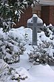 Snow covered Celtic cross in memorial garden