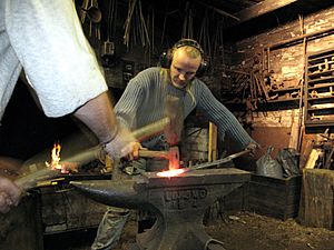 3 tourist helping artist blacksmith in finland