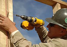US Navy 061125-N-6889J-033 Builder 3rd Class Mathew Speece of Naval Mobile Construction Battalion Seven Four (NMCB-74) secures the frame of a wall at Camp Ramadi