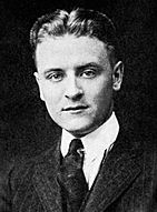 Photograph of F. Scott Fitzgerald as a student at Princeton. The photo features only his head and shoulders. He is wearing a dark tie and a pin-striped suit.  His hair is parted in the middle and neatly coiffed.