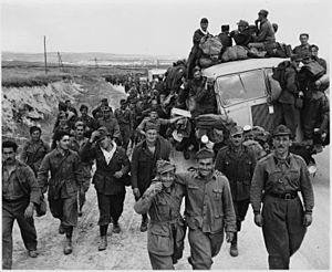 Axis prisoners of war are herded out of the city as Allied armies enter Tunis. - NARA - 195472
