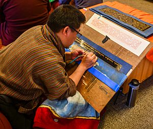 Bhutanese calligrapher writing gold Kangyur