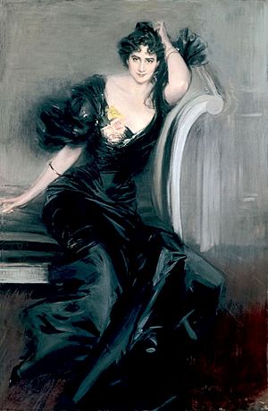 Full length portrait of a seated woman wearing a long, black gown