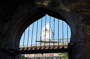 A view of the clock tower in House of Wonders through Islamic styled door in the Stoen City of Zanzibar