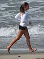 Woman running barefoot on beach