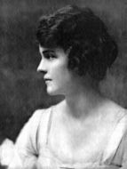 Photographic portrait of Chicago heiress Ginevra King as a young woman. The black and white photo features her left profile, and she is wearing a white dress with ruffled sleeves. Her hair is dark, wavy, and bobbed.