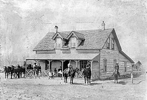 Urch Family and friends posed in front of the Urch Ranch Home (also known as the Half-Way House) near Monarch