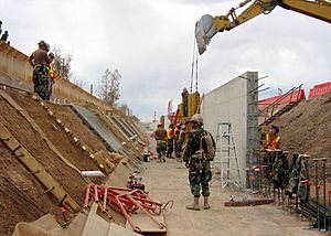 US Navy 090314-N-5253T-010 eabees assigned to Naval Mobile Construction Battalions (NMCB) 133 and NMCB-14 construct a 1,500 foot-long concrete-lined drainage ditch and a 10 foot-high wall to increase security along the U.S. and