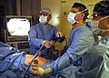 US Navy 060227-N-9742R-004 The Ship's Surgeon Lt. Cmdr. Michael Barker, center, and Senior Medical Officer Commander David Gibson, left, perform an urgent laparoscopic appendectomy