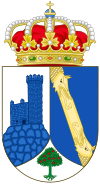 A shield with a crown on top. The shield is divided in three parts, having the left part an image of the watchtower of Torrelodones, colored blue with a white background, the right side has two dragon looking yellow creatures facing each other over a blue background, and on the bottom part is a small green three with red fruits over a white background