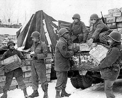 Soldiers load trucks with rations