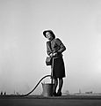 A female Fire Guard using a stirrup pump on the roof of a building in London, 1941. D5007