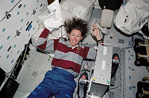 STS-112 Sandra Magnus washes her hair in the middeck of Atlantis