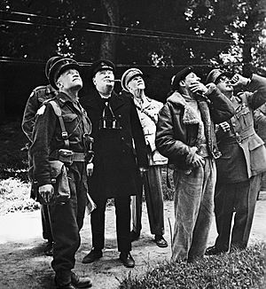 Winston Churchill and senior Allied commanders looking up at aircraft activity overhead during a visit to General Montgomery's headquarters in Normandy, 12 June 1944. B5364
