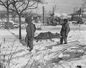 "Body of American soldier is borne on stretcher from terrain in vicinity of Malmedy, Belgium, where on or about 17 Decem - NARA - 532956