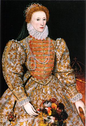 Full-length portrait of Queen Elizabeth in her early 40s. She has red hair, fair skin, and wears a crown and a pearl necklace.