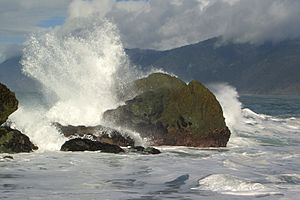 Waves Crashing on Rocks (910358858)