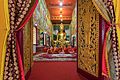 Open front door over Wat Mixay and praying bhikkhus, Vientiane, Laos