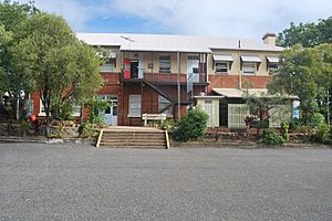 Former Science Block and Workshop, from E, with stone and concrete retaining wall (EHP, 2015)