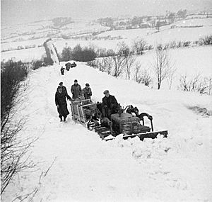 A bulldozer, tractor and sledge deliver bread to the snowbound village of Llanwddyn (15796330210)
