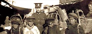 Canadian Pte Edwin Stephenson poses with boys in Vladivostok in 1919