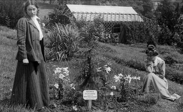 Adela Pankhurst and Annie Kenney by a tree planted by Emmeline Pankhurst