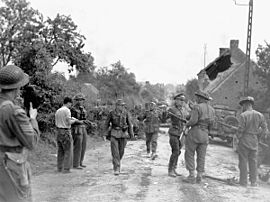 Major David V. Currie (left, with pistol in hand) of The South Alberta Regiment accepting the surrender of German troops at Saint-Lambert, on 19 August 1944