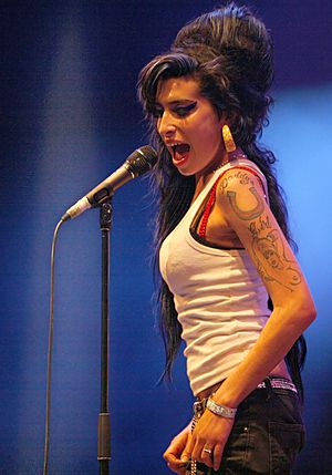 Winehouse singing in front of a microphone, looking to the side.