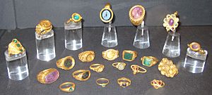 22 gold and jewelled rings in a display case