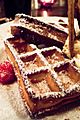 Thick, rectangular waffle deeply browned and topped with powdered sugar.