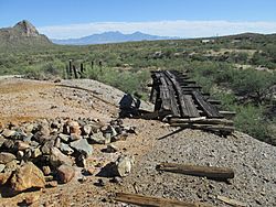 Mine dump and ruins of rail haulage at San Xavier. Helmet Peak is at the left and the Santa Rita Mountains are in the background.