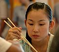 Girl with chopsticks at dumpling restaurant