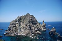 A steep, rocky island surrounded by dark blue sea