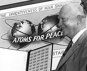 "ATOMS FOR PEACE" 3 cent stamp art detail with President Eisenhower in 1955 and quotation of "THE... INVENTIVENESS OF MAN SHALL" from- HD.3C.032 (10692189783) (cropped)