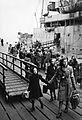 A Dutch school teacher leads a group of refugee children just disembarked from a ship at Tilbury Docks in Essex during 1945. D24064
